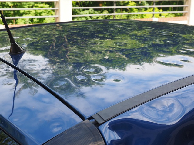 Dunkelblaues Auto mit vielen Beulen am Dach durch Hagelschlag